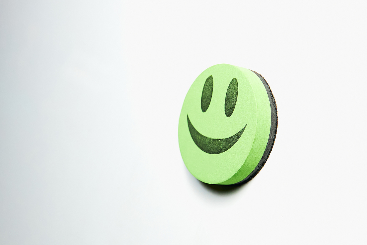 Green smiley face glued to white background